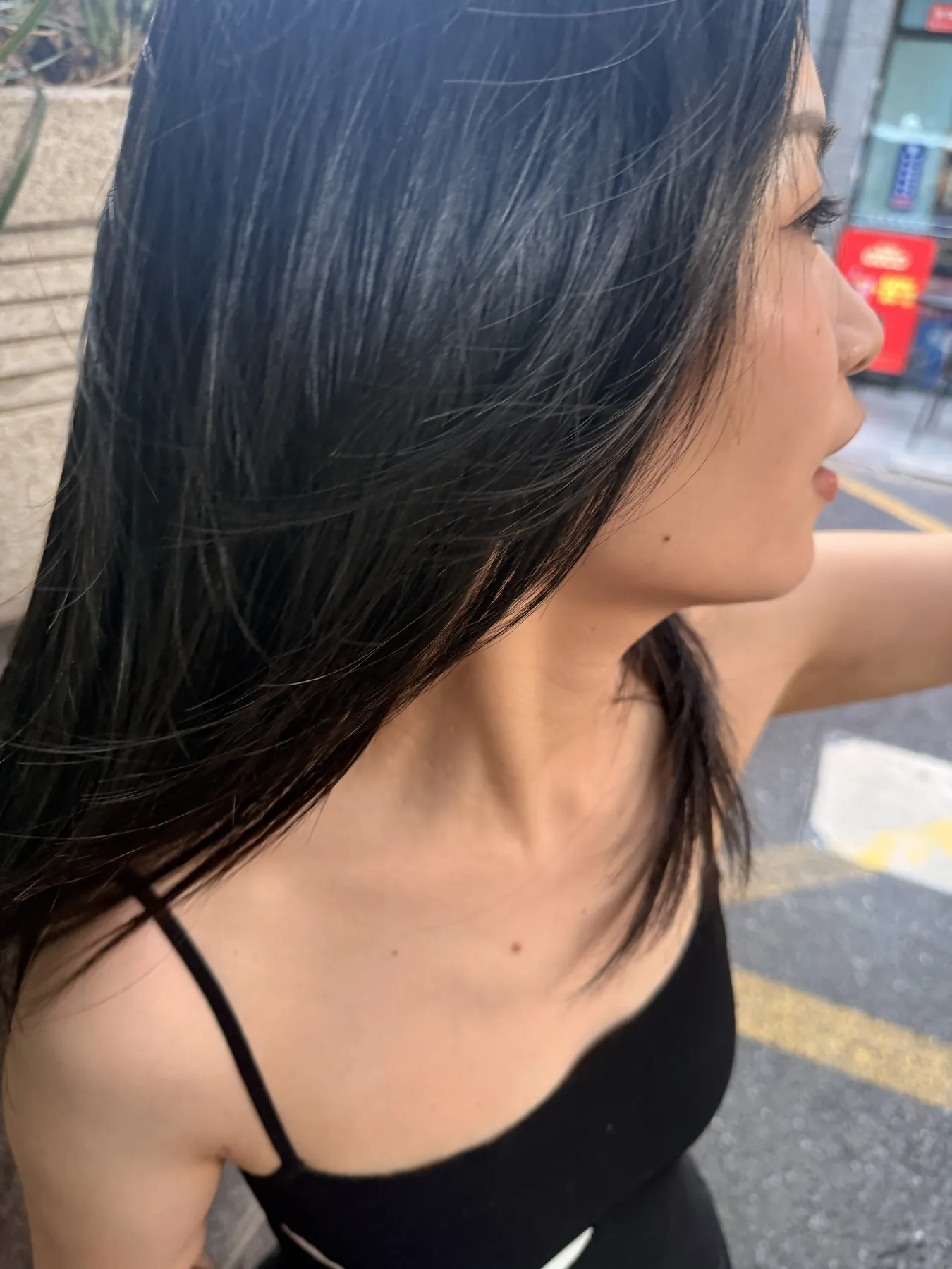 街边抓拍的 Aria 侧脸,长发被风吹到肩后